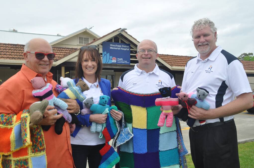 Great donation: Wauchope Hospital Volunteers president Roger Adams and Rotary e-Club of NextGen members Jackie Jones, president Peter Saville and Tim Walker with some of the knitted items destined to raise funds for Wauchope District Memorial Hospital.