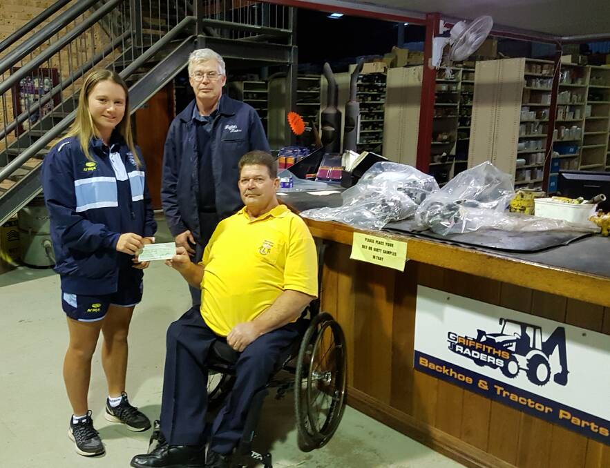 Touch rugby star Emily Wright receives a cheque from sponsor Terry Griffiths of Griffiths Traders and Stephen Perkins, the chairman of the Lions Sports Foundation of Wauchope.