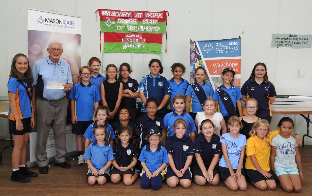 HELPING THE GIRL GUIDES: Glen Leonard from Lodge Star of Wauchope presents a cheque for $2,000 to the Wauchope guides to help pay their rent.