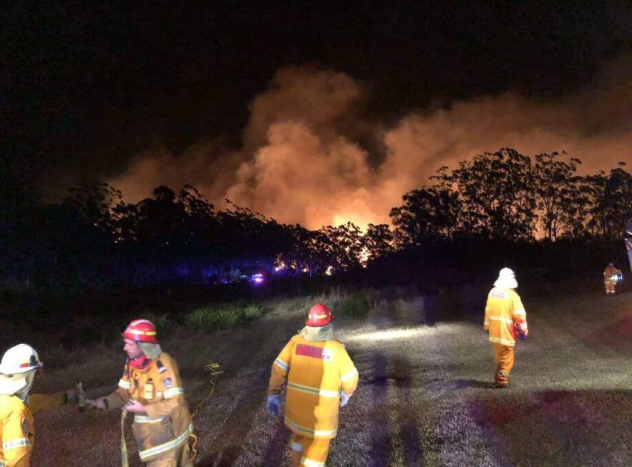 Volunteer firefighters protecting homes near Comboyne on Sunday night. Photo courtesy of Sancrox/Thrumster Rural Fire Brigade.