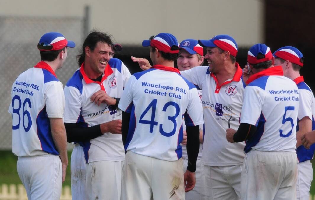 Legend: An jubilant Brad Baxter congratulates stand out bowler Jason Blythe for his brilliant nine-wicket performance in the grand final at Oxley Oval.				Pic:MATT McLENNAN