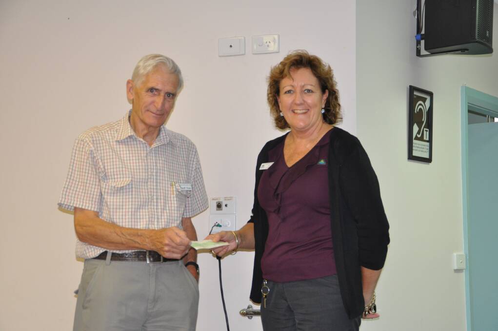 Job well done: Wauchope Seniors Treasurers Hall Committee member Geoff Trick presenting Lyn Collins from Port Macquarie Hastings Council with the cheque for $10,000 for repairs to the Senior Hall.