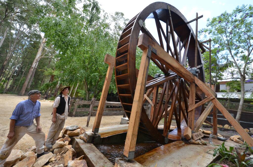 Rock crushing operater David Outred and Gold proseptor Aiden Waite staff at Timber town looking at the Water Wheel that was built by the Wood Workers Guild who operate their club out of the theme park.