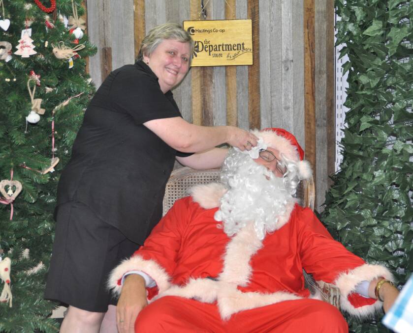 The busiest man in town: An exhausted Santa was helped by Sue Farlow from the Department Store after he finished his run around town last week