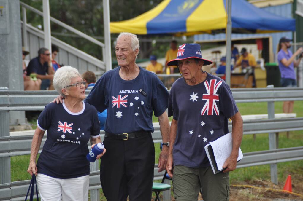Looking the part: Pam and Ron Dures, left, and John Eggert walk back to the stands after their stint as members of the Sing Australia choir during the Australia Day celebrations at Wauchope on Monday.