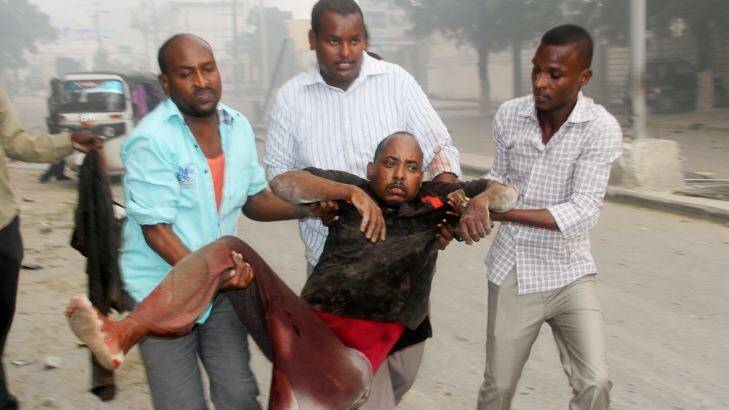 Somali men help a wounded civilian who was wounded in a suicide car bomb attack. Photo: Farah Abdi Warsameh