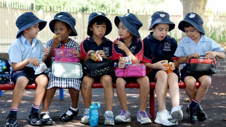 Students sit at St Oliver's Primary School in Harris Park where there is a compulsory hat policy. Photo: Steven Siewert