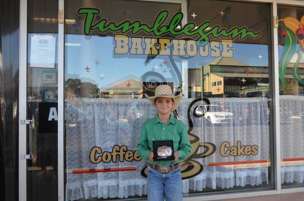 Champion: Levi Ward proudly holds up his new buckle in front of his major sponsor Tumblegum Bakehouse. Photo: Callum McGregor.