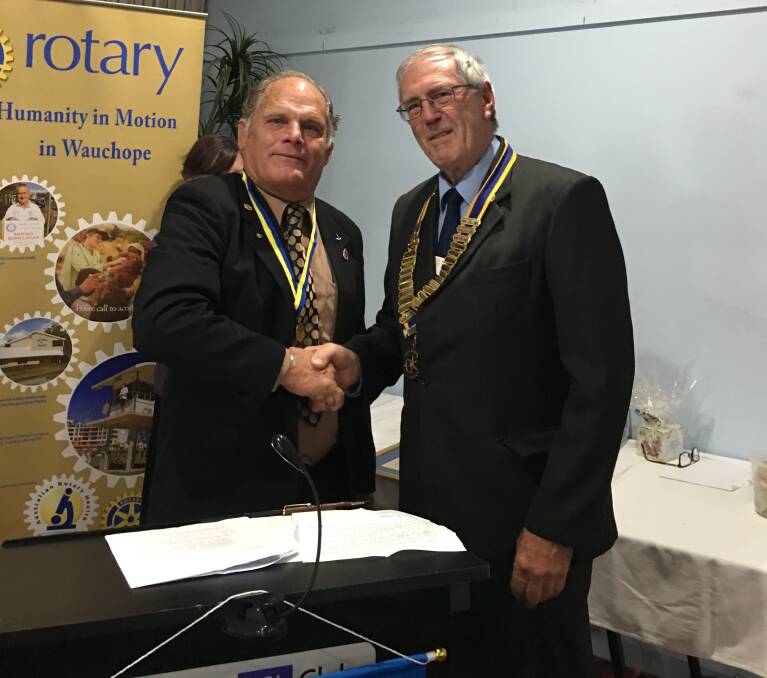 Looking ahead: Outgoing Rotary president Reg Pierce congratulating incoming boss George Campbell.