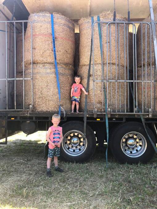 Helpers: Tai and clay Hamilton inspecting the truck load of hay and mineral blocks sent to drought-raved farmers.