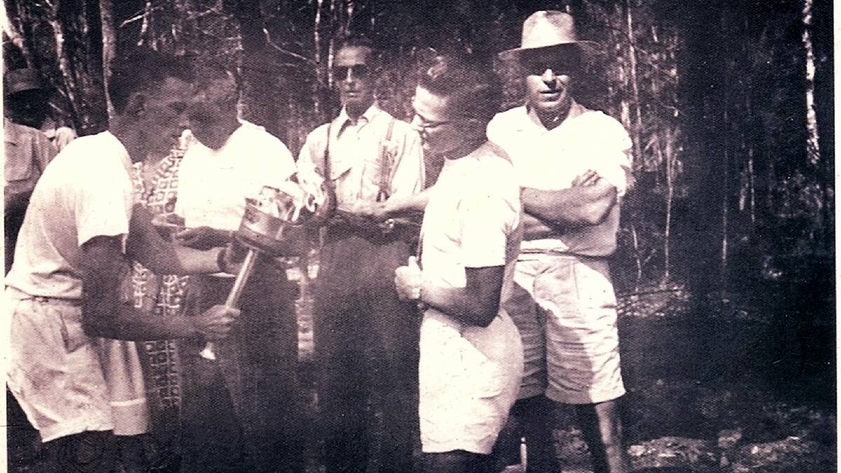 MAKING HISTORY: Olympic torch bearers on the Pacific Highway in 1956 handing over to Don Monkley (right, wearing glasses) and spectator Anton Deegenaars (far right). Photo courtesy of Rhonda Pearce and Wauchope History on Facebook.