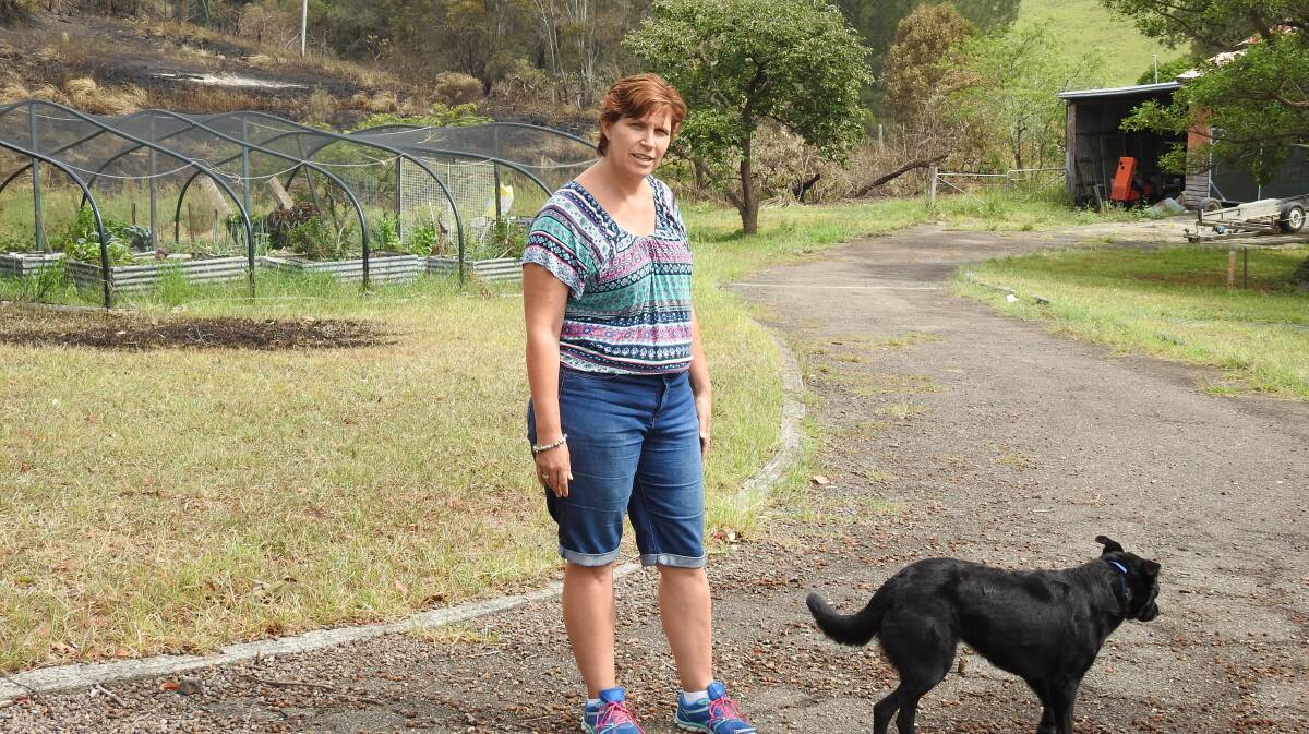 LUCKY ESCAPE: Heather Smith and her dog, Poppy outside their home which escaped the fire raging around it.