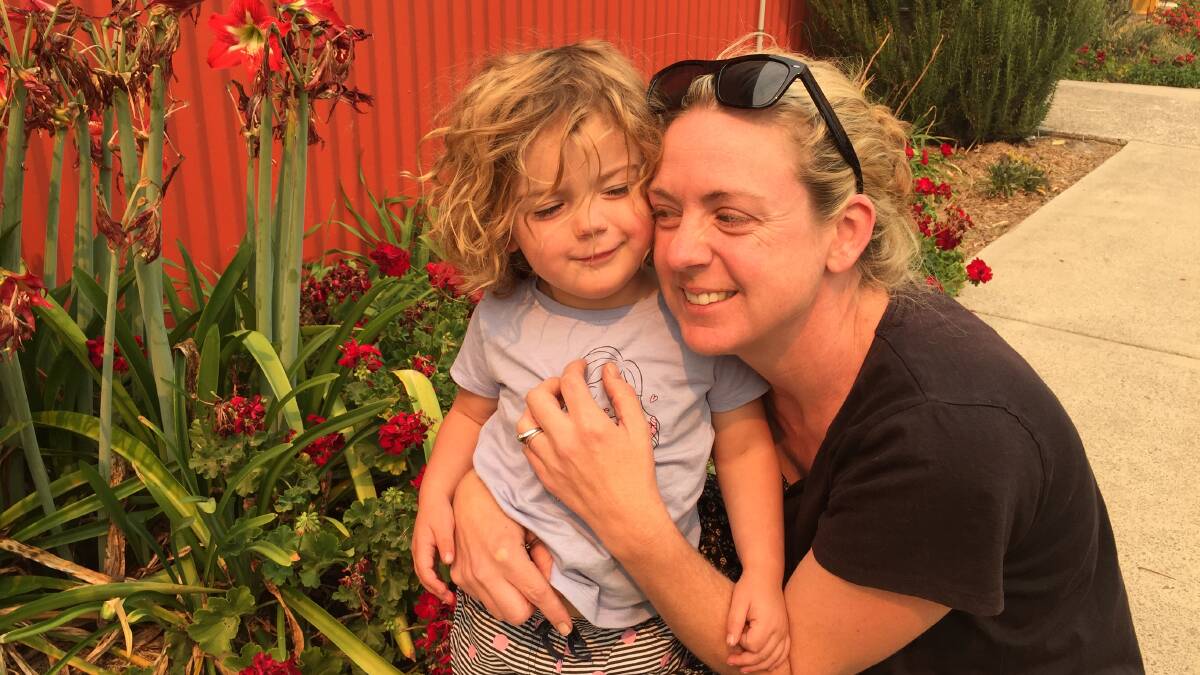 PRECIOUS HUGS: Laura Roots cuddles her daughter, Phoebe, at Hollisdale Hall, after they survived the Upper Pappinbarra bushfire. Photo: Letitia Fitzpatrick.