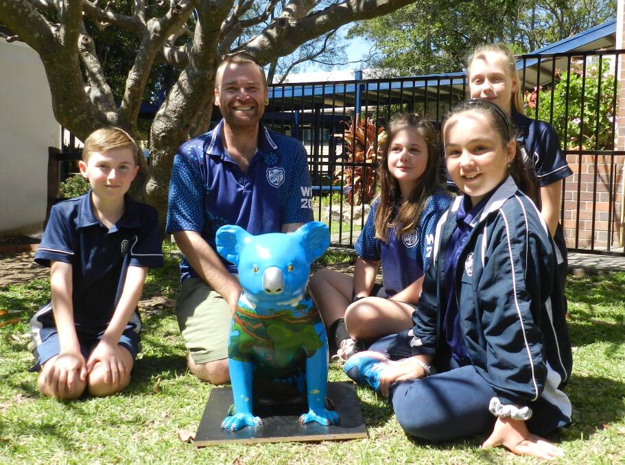 CUTE AND CUDDLY: Students from Wauchope Public School with the koala they designed.