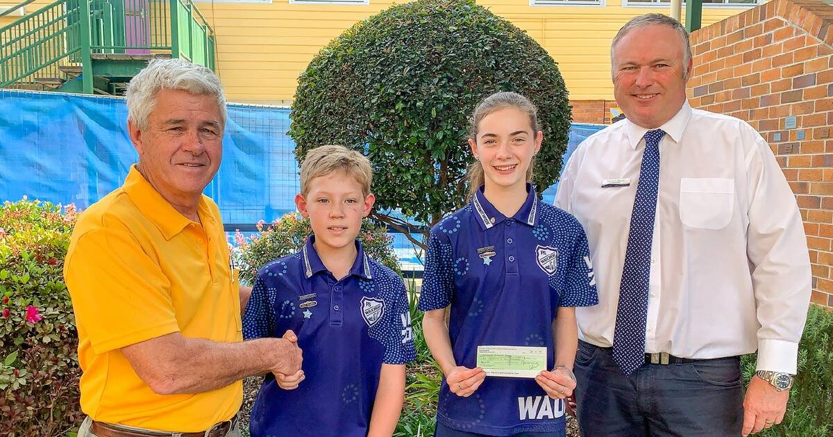 CARING LIONS: Lion Greg Cavanagh presents a cheque to Wauchope Public School captains Dylan Taylor and Tiana Daly and principa Cameron Osborne.