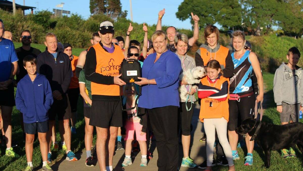 Wauchope parkrun accept their new defibrillator from Hastings Co-op's Nicole Langdon.