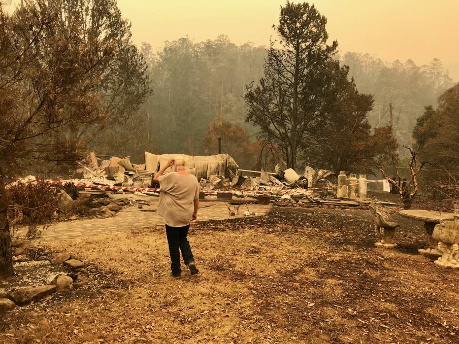 SURVEYING THE WRECKAGE: Suzie West lost her home in the Upper Pappinbarra bushfire in November. BlazeAid are helping her rebuild. Photo supplied.