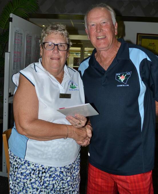 DELIGHTED: Kathryn Guyer receives her award from Peter Taylor of NSW Veteran Golfers Association.