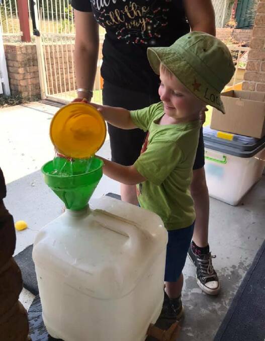 LITTLE GREEN FINGERS: Four-year-old Lachlan Bulley collects water for the garden at TG's Childcare in Wauchope.
