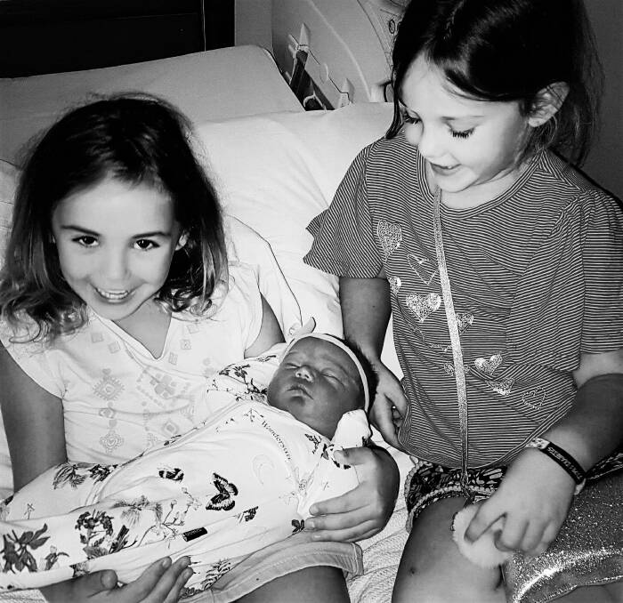 Baby Darci Keaton with her delighted big sisters.