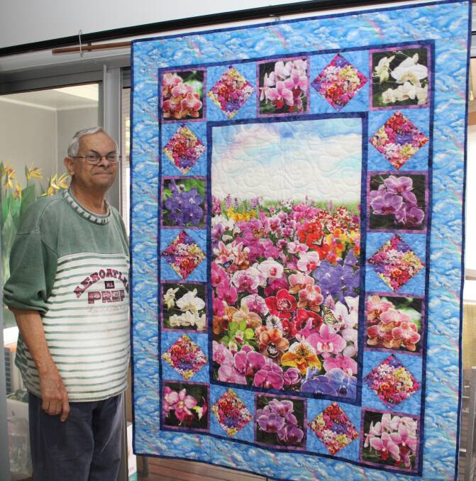 Colourful: Greg Elliott with the beautiful quilt made by Kathy Hancock, which is being raffled as a fundraiser in support of Wauchope District memorial Hospital palliative care patients.