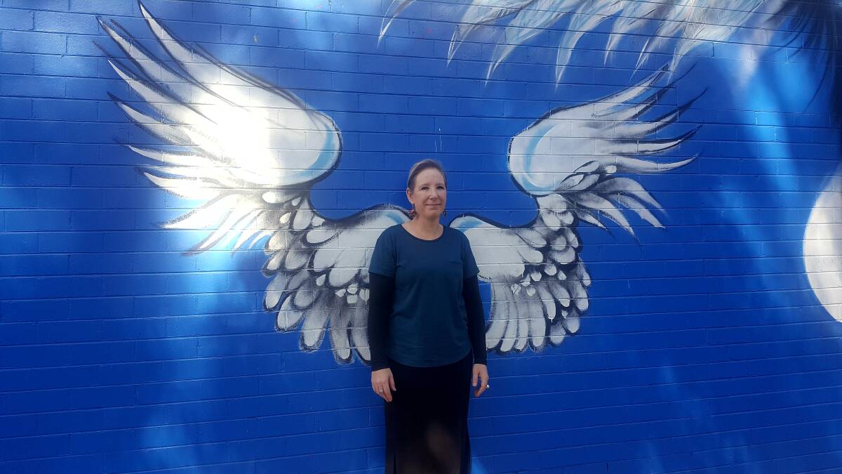 WINGS: Skye Petho with the iconic wings mural which will stay as a reminder of what the charity has achieved. PHOTO: Laura Telford.