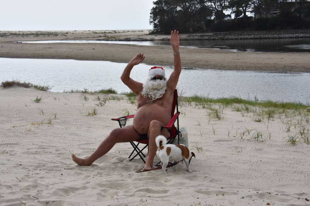 MERRY CHRISTMAS: Santa Ron Hunter from his deck chair at Lake Cathie. PHOTO: Laura Telford.