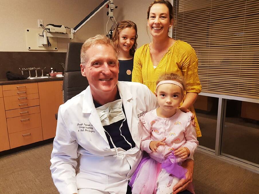 Surgery success: Willow Powick (right) sitting with her surgeon Dr Roberson, with her sister and mum Skye (behind). 