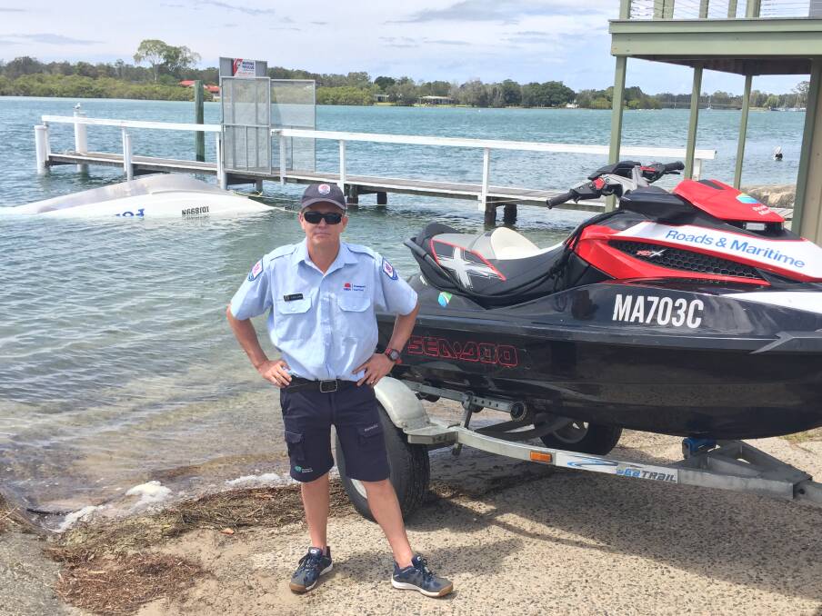 Camden Haven Marine Rescue unit commander Ken Rutledge with the upturned vessel involved in the incident on December 3. 