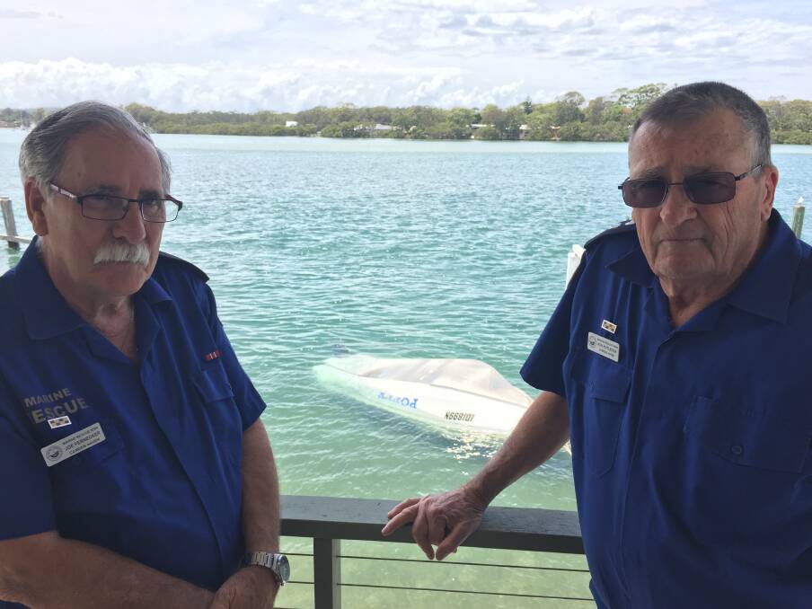 Tragic incident: Marine Rescue Camden Haven Unit's Joe Pernecker and commander Ken Rutledge with the upturned vessel involved in the incident on December 3. 