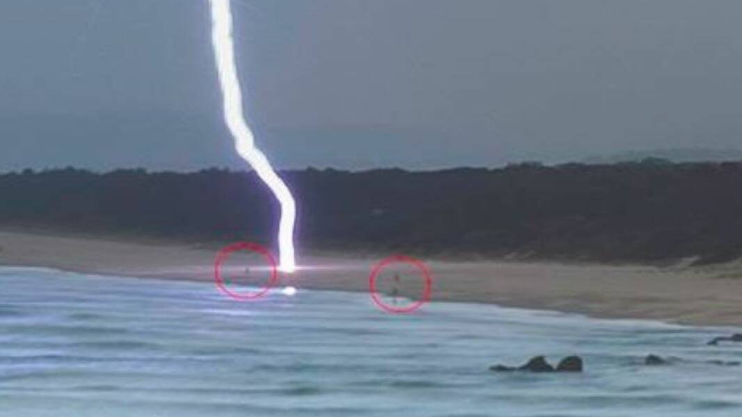 So close: Two people on the beach at Lighthouse when the lightning struck. Photo: Bryan Jones.