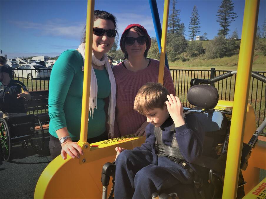 Here we go: Pip Cullen and Emily and Arthur Kinney preparing for the first ride in the newly-opened Liberty Swing on Town Beach Reserve on Thursday morning.