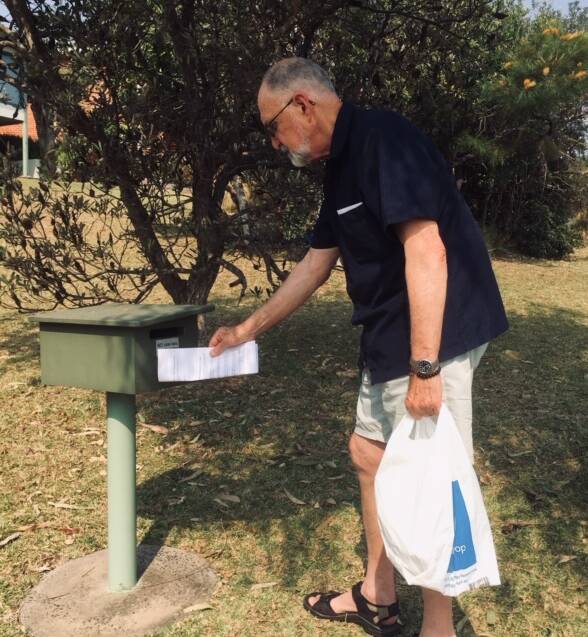 Community push: Frank Dennis drops information in a letterbox urging people to lodge submissions about the Sancrox Quarry expansion proposal.