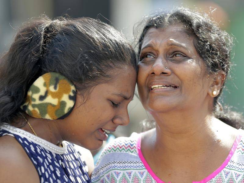 Sri Lankan Catholic women cry outside a church hit by a bomb attack in Colombo a month ago.